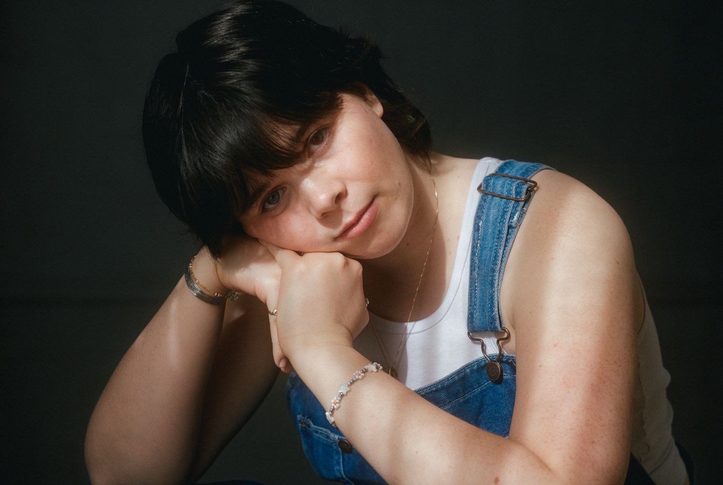 Leith Ross wearing a white vest and blue denim dungarees